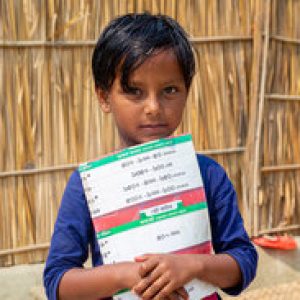 Bangladesh – March 06, 2021: Laila age 7, a village student kid looking at the shy face and holding a book at Majherchor, Chandpur, Chittagong.